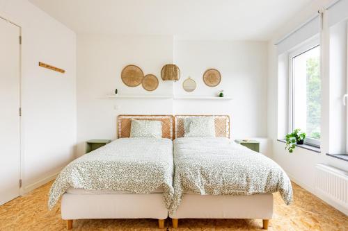 a white bedroom with a bed and a window at Le Gîtel in Spa