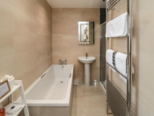 een badkamer met een bad en een wastafel bij Whinny Cottage in Alnwick