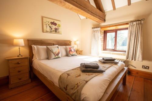 sypialnia z dużym łóżkiem i oknem w obiekcie The Threshing Barn w mieście Woodhall Spa