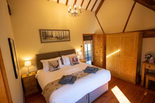 a bedroom with a large bed with two towels on it at The Threshing Barn in Woodhall Spa