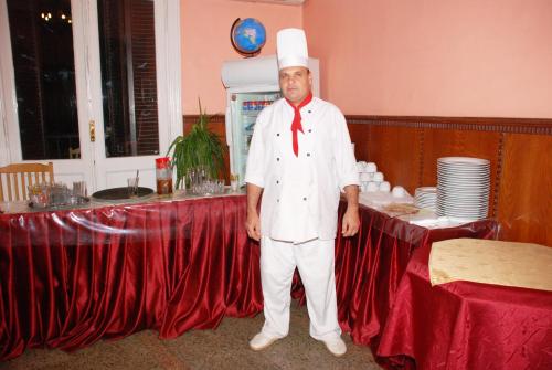 a man in a chefs hat standing in front of a table at City View Museum Hotel in Cairo