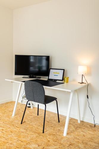 a white desk with a computer and a chair at Le Gîtel in Spa