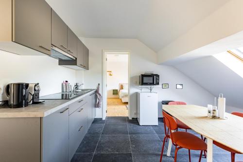 a kitchen and dining room with a table and chairs at Le Gîtel in Spa
