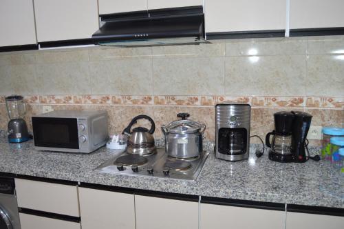 un comptoir de cuisine avec une cuisinière et un micro-ondes dans l'établissement Résidence Hôtelière El Marraki, à Nador