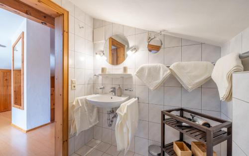 a bathroom with a sink and a mirror and towels at Ferienwohnung Rauschbergblick in Ruhpolding