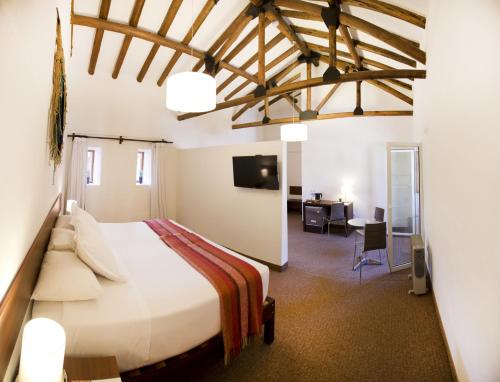 a bedroom with a large bed and a desk at Tierra Viva Cusco Centro in Cusco