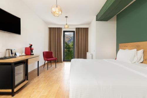 a hotel room with a bed and a desk at Intourist Kazbegi in Stepantsminda