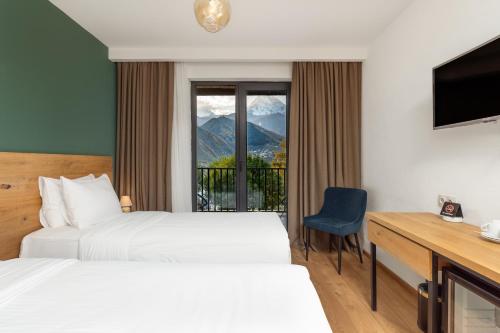 a hotel room with two beds and a window at Intourist Kazbegi in Stepantsminda