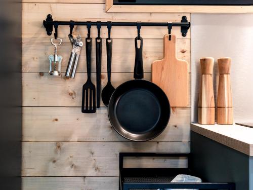 a frying pan and utensils hanging on a wall at Chic Sauna Cabin Near the Sea - KOHIN Cabin Nº02 in Tsitre