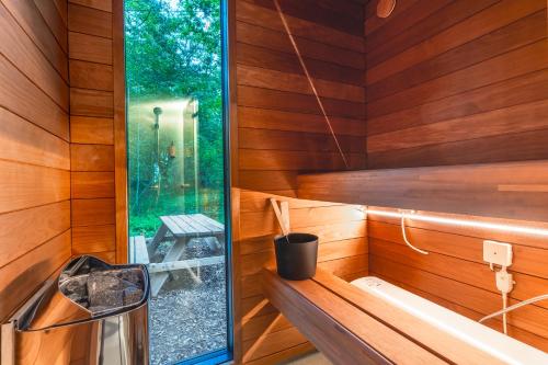 a sauna with wooden walls and a window at Chic Sauna Cabin Near the Sea - KOHIN Cabin Nº02 in Tsitre