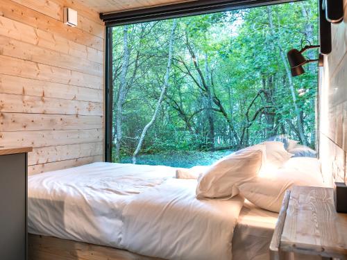 a bed in a room with a large window at Chic Sauna Cabin Near the Sea - KOHIN Cabin Nº02 in Tsitre