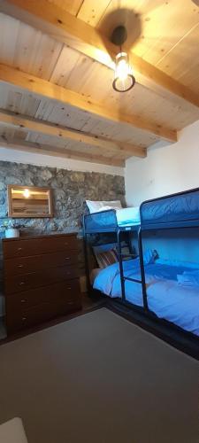 two bunk beds in a room with a stone wall at Point of view 1 in Pramanta