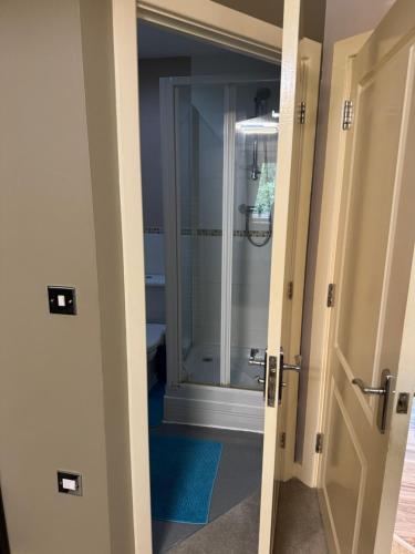 a bathroom with a shower and a glass door at Grove flat - two bedroom flat in central Dunstable in Dunstable