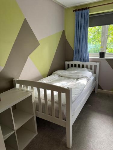 a childs bedroom with a striped wall at Grove flat - two bedroom flat in central Dunstable in Dunstable