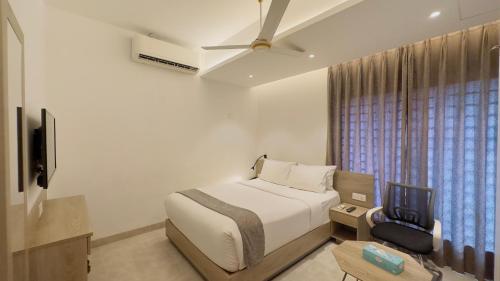 a bedroom with a bed and a tv and a window at Priyo Nibash Stylish Residential Hotel in Dhaka