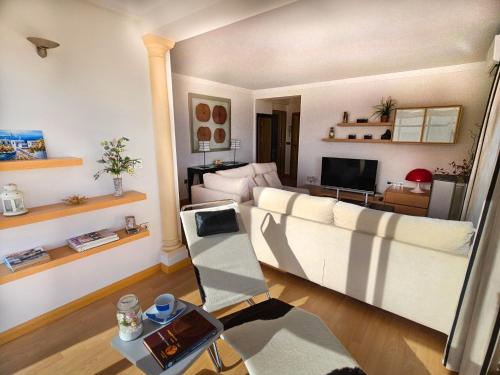 sala de estar con sofá blanco y TV en Luxury House Relax - Alojamientos La Torre, en Torre del Mar