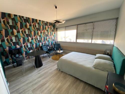 - une chambre avec un lit et un mur aux motifs colorés dans l'établissement Studio centre-ville, à Montceau-les-Mines