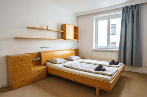 Schlafzimmer mit einem Bett und einem Fenster in der Unterkunft Central Living Apartments - Schottentor in Wien