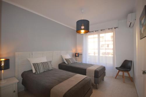 une chambre avec deux lits et une chaise et une fenêtre dans l'établissement 