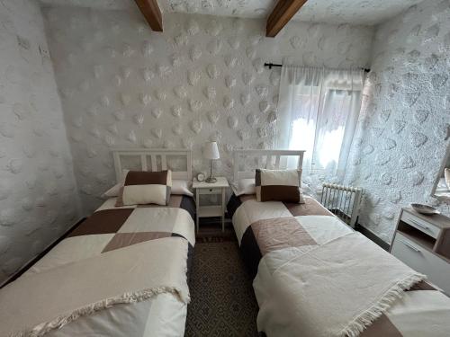 a bedroom with two beds and a table and a window at Casa Rural Juli in Santa Cruz de Tenerife