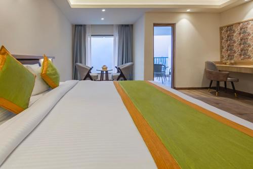 a hotel room with a large bed with a green rug at Sterling Nainital in Nainital