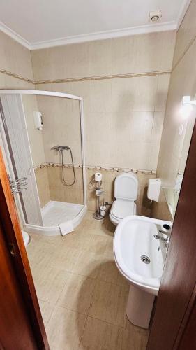 a bathroom with a shower and a toilet and a sink at Residencial A Cista in Vila da Ponte