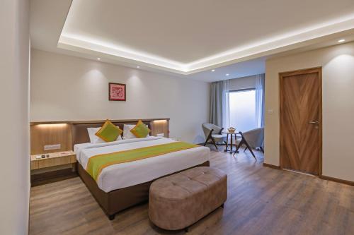 a hotel room with a large bed and a chair at Sterling Nainital in Nainital