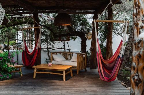 a porch with hammocks and a couch and a table at Can Vistabella Boutique Resort in San Antonio