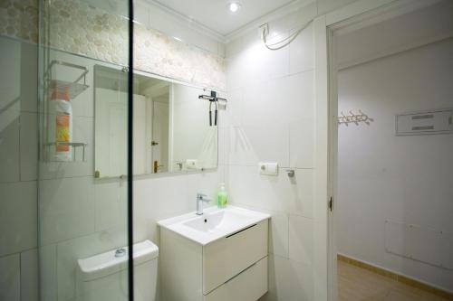 a white bathroom with a sink and a mirror at 027 La Mata View Natural Park in La Mata