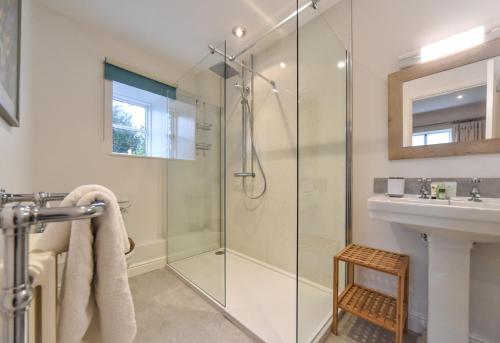 a bathroom with a glass shower and a sink at Raikes Barn in Hartington