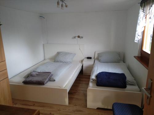 two beds in a room with white walls at " Haus Willi " Sohlbach in Netphen