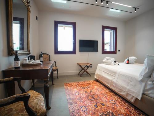 een slaapkamer met een bed, een bureau en een televisie bij Foresteria Castello di Perno in Monforte dʼAlba