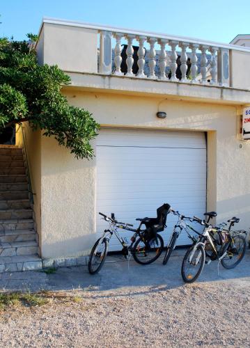 due biciclette parcheggiate di fronte a un garage di Lokunja Bed&Breakfast a Pag