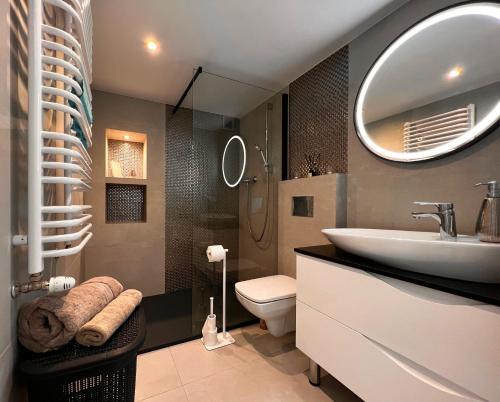 een badkamer met een wastafel, een toilet en een spiegel bij Apartament Przy Rynku in Kielce