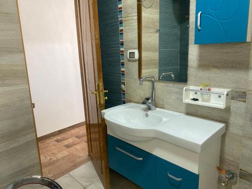 een badkamer met een witte wastafel en een spiegel bij Capital of Sun in Luxor