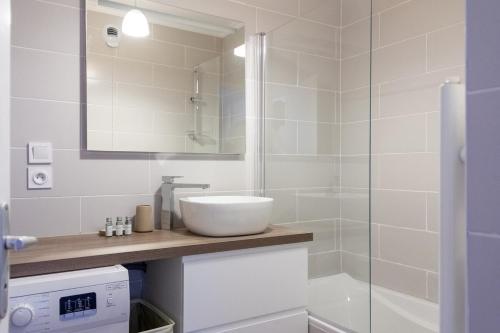 La salle de bains blanche est pourvue d'un lavabo et d'une douche. dans l'établissement ZenBNB / ZEBRA / 2 min. Gare /Tramway / 3Pers/ Stationnement, à Annemasse