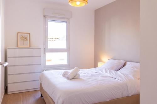 une chambre blanche avec un lit et une fenêtre dans l'établissement ZenBNB / ZEBRA / 2 min. Gare /Tramway / 3Pers/ Stationnement, à Annemasse