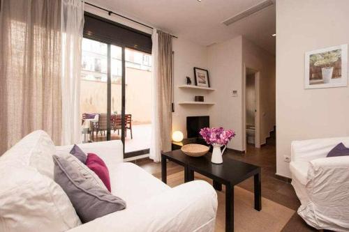 a living room with a white couch and a table at Port I Espectacular apartament con terraza in Barcelona