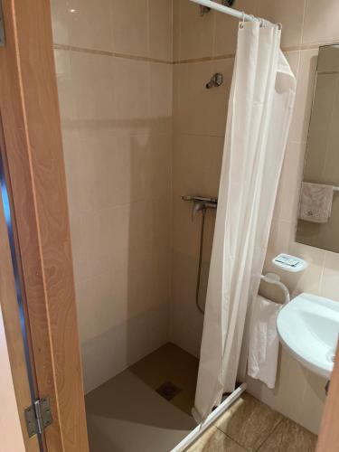 uma casa de banho com um chuveiro, um WC e um lavatório. em Hostal Restaurant El Poligono em Valência