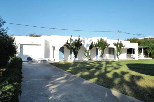 a large white house with trees in the yard at Villa Omega Guest House in Kokkali, Leros in Gourna