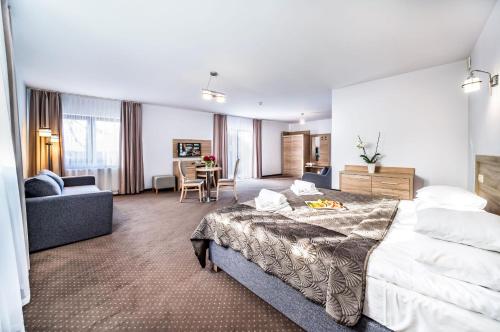 una camera d'albergo con un grande letto e un soggiorno di Sunset Spa a Rewal