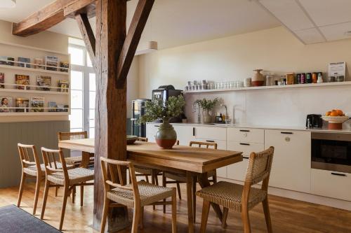 a kitchen with a wooden table and chairs at Hôtel Gambettes - Entrée autonome, réception en ligne - Encore Mieux in Limoges