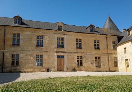 un gran edificio de piedra con una puerta grande en 3 Gîtes avec piscine au Château de Charbogne 