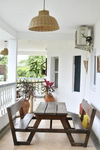 a wooden table and chairs in a room with a balcony at Tulia House Backpackers in Mombasa