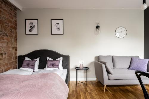 1 dormitorio con 1 cama, 1 silla y 1 reloj en RentPlanet - Apartament Rydygiera, en Wroclaw