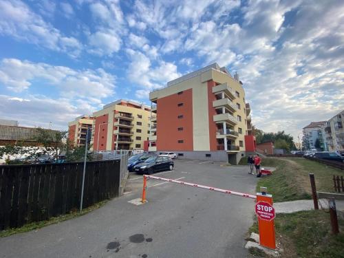 a parking lot with a stop sign and some buildings at Fortuna Park Apartman in Sfântu-Gheorghe