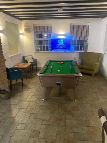 a room with a pool table and a tv at The Berkeley in Peopleton