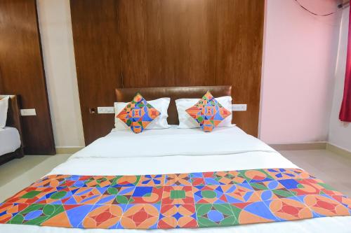 a bed with a colorful comforter and pillows at FabExpress Raj Imperial By Rivasa in Goa