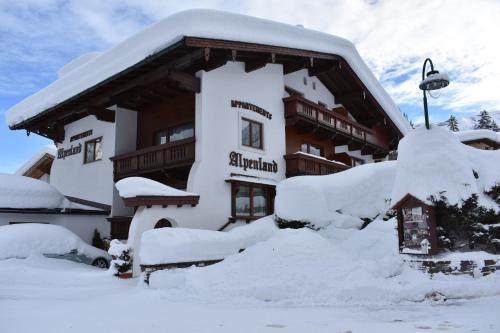 un edificio cubierto de nieve delante en Appartements Alpenland Pertisau, en Pertisau