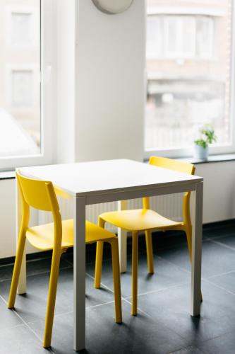 a table and two yellow chairs in a room at Le Gîtel in Spa